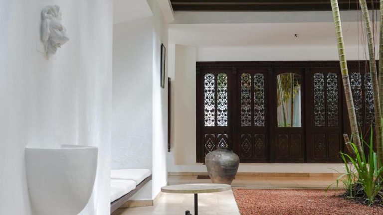 Elegante entrada con puertas de madera tallada y decoración colonial en Jetwing Ratnam Residence Sri Lanka