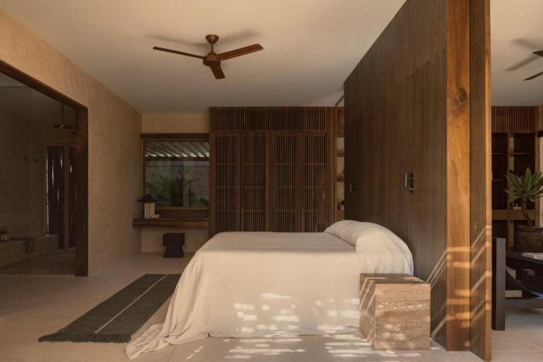Habitación principal con paredes de madera oscura y ventilador de techo en NABOA Hotel Tulum