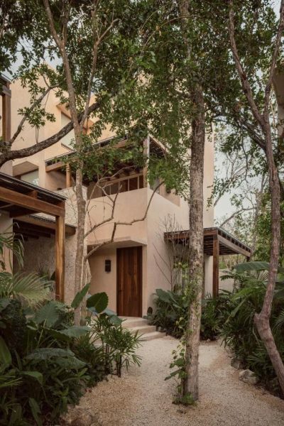 Entrada principal con jardín tropical y sendero de piedra del NABOA Hotel Tulum entre árboles y vegetación