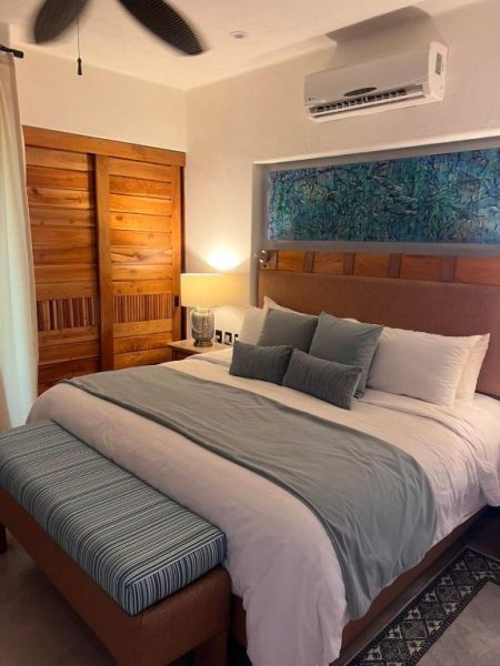Habitación con cama king size y cabecero de madera en Condominio Panamá con aire acondicionado