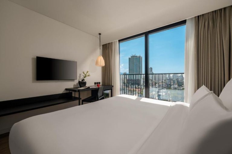 Habitación doble con cama king, televisión y balcón con vistas a la ciudad en Caro Premium Danang Hotel