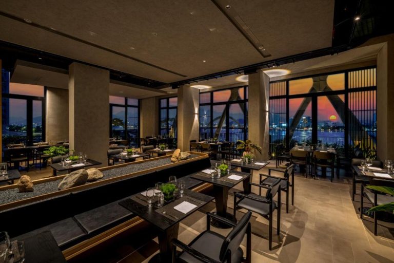 Restaurante panorámico del Caro Premium Danang Hotel con vistas al río Han al atardecer