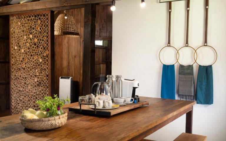 Zona de café y desayuno con mesa de madera y decoración bambú en Sre Lodge Living Style Community