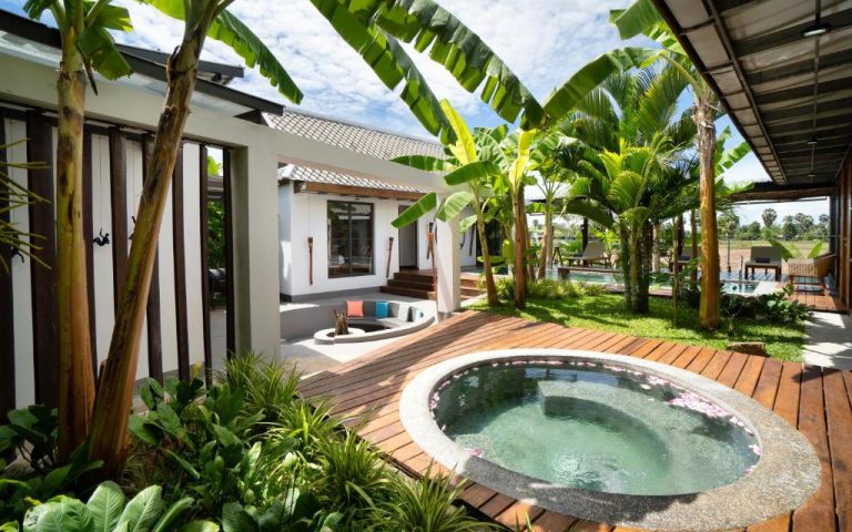 Piscina privada redonda con deck de madera y jardín tropical en Sre Lodge Living Style Community