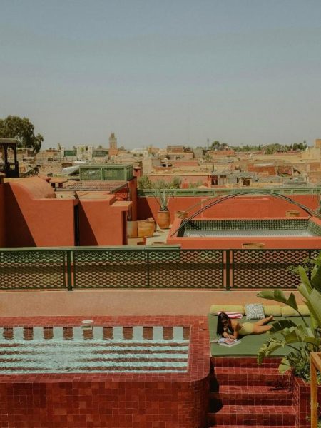 Terraza con piscina y zona de descanso en The Mellah Hotel con vistas a los tejados de Marrakech