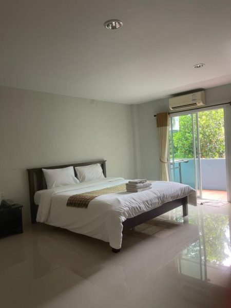 Habitación doble con cama matrimonial y balcón con vistas al jardín en Baansupmongkol Krabi