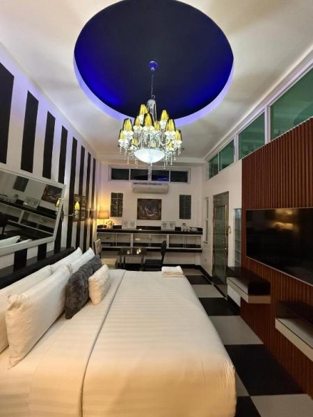 Suite de lujo con cama king, candelabro dorado y techo azul en Italy Condotel Darasa