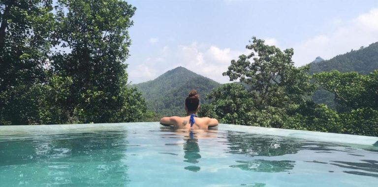 Piscina infinita con vistas a las montañas tropicales del AHAS GAWWA Eco Lodge rodeada de vegetación