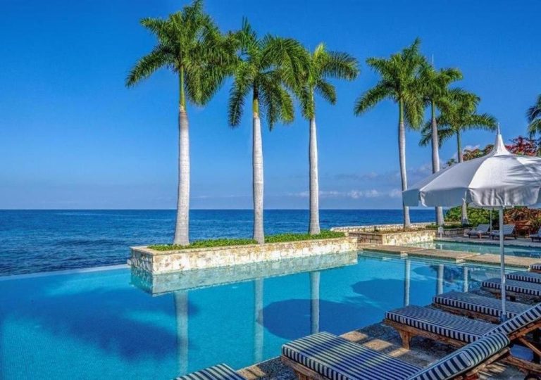 Piscina infinita con palmeras y vistas al mar Caribe en Round Hill Hotel & Villas Jamaica