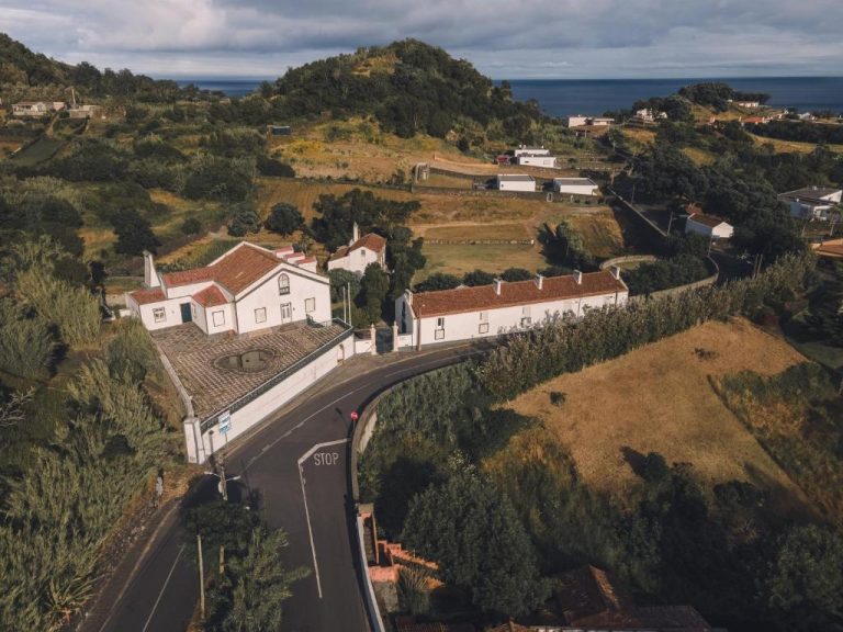 Vista aérea de los Apartamentos da Galé con casas blancas, tejados rojos y paisaje verde junto al mar