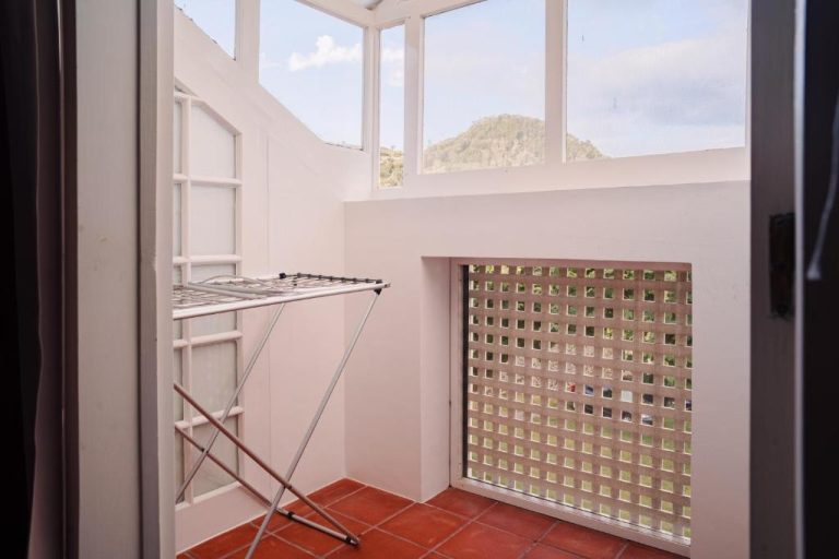 Balcón con tendedero plegable y celosía en Apartamentos da Galé con vistas a la montaña