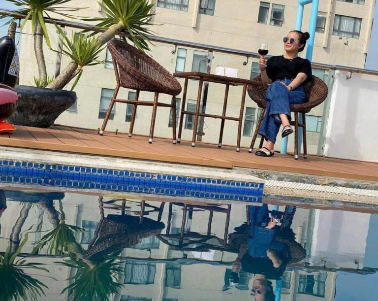 Terraza con piscina y zona lounge en Phuong Tran Apartment and Hotel con vistas al edificio