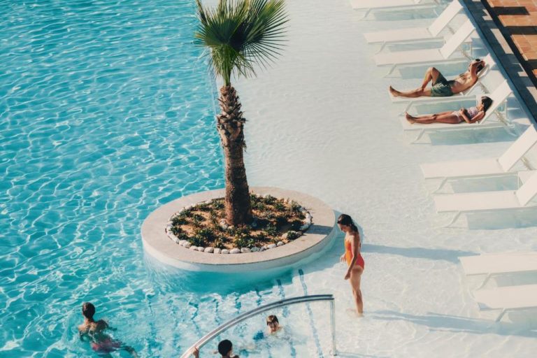 Piscina exterior con palmera central y tumbonas del Iberostar Selection Eolia Djerba en Túnez