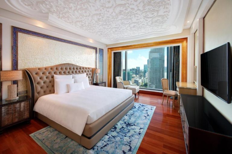 Habitación de lujo con cama king y vistas panorámicas a la ciudad en The Reverie Saigon