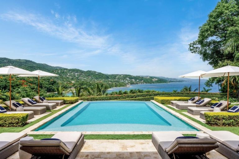 Piscina infinita con tumbonas y vistas al mar del Round Hill Hotel & Villas en Jamaica