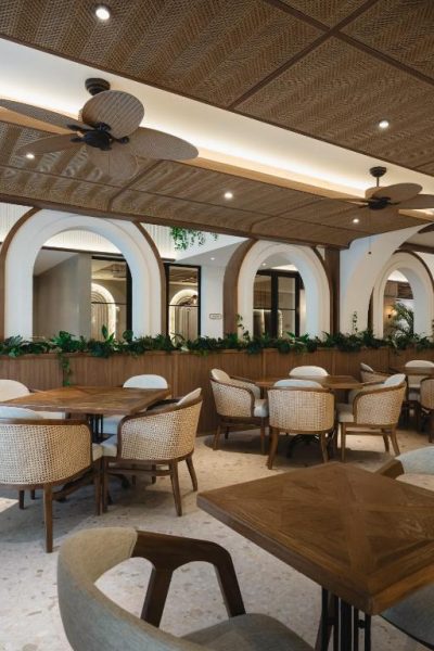Restaurante del Hygge Hotel and Villas Seminyak con sillas de ratán, techos de mimbre y arcos decorativos