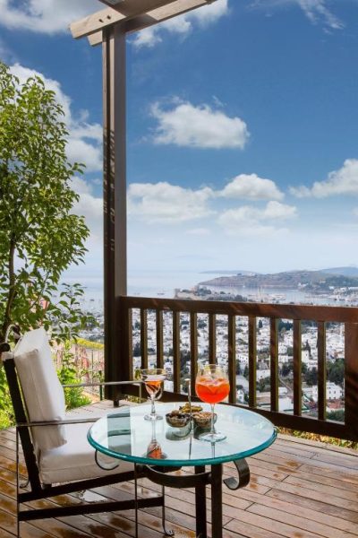 Terraza con cócteles y vistas panorámicas al mar y la ciudad en The Marmara Bodrum Adult Only