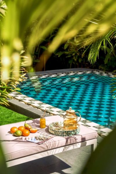 Terraza con piscina de mosaicos y bandeja de té con frutas frescas en President Maison Signature