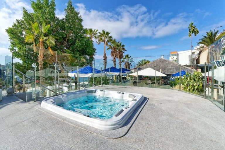 Jacuzzi exterior con vistas al jardín y palmeras en el Aparthotel Maracaibo