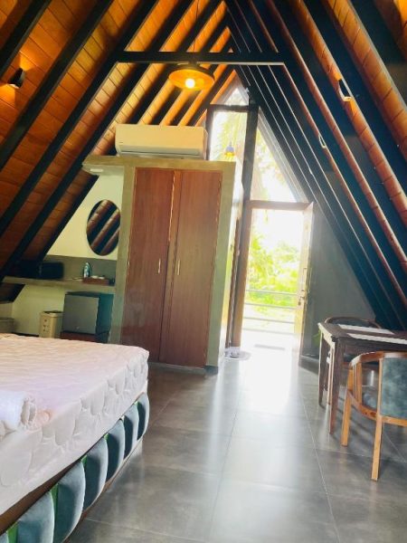 Habitación tipo cabaña con techo triangular de madera y balcón en Avinka Grand