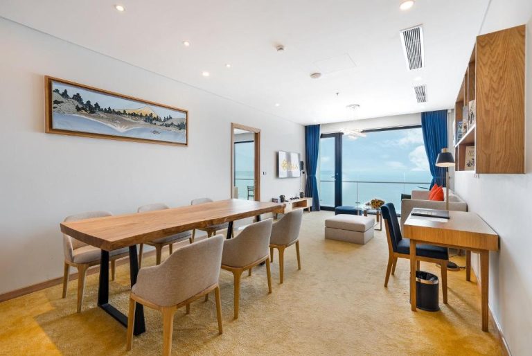 Comedor moderno con mesa de madera y vistas al mar en Sala Danang Beach Hotel, Vietnam