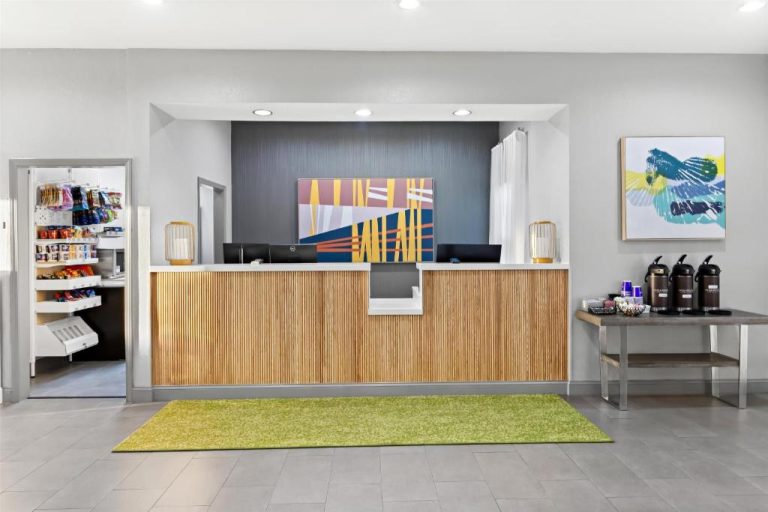 Recepción moderna con mostrador de madera y área de snacks en Spark by Hilton Panama City Beach