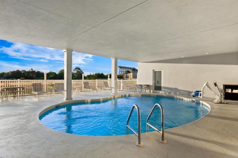 Piscina interior climatizada del Spark by Hilton Panama City Beach con terraza y vistas al exterior
