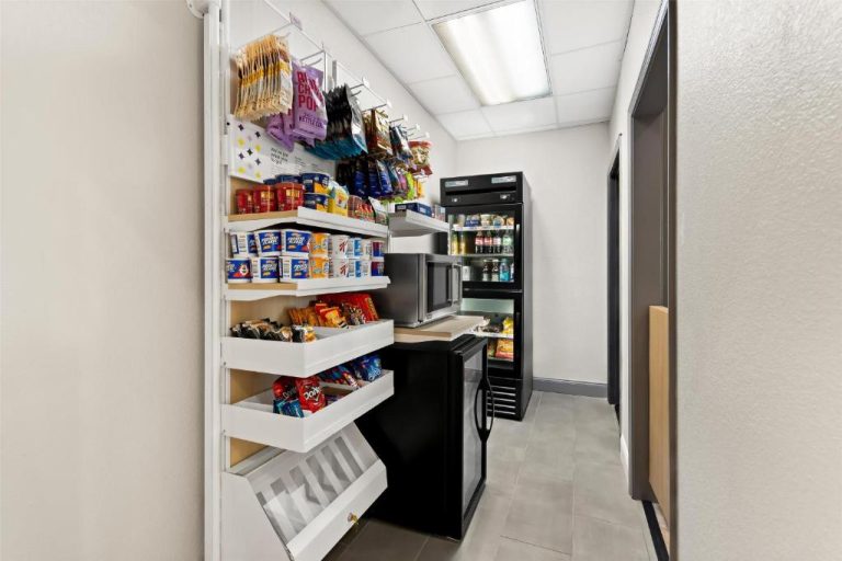 Tienda de snacks y bebidas con estantes surtidos y microondas en Spark by Hilton Panama City Beach