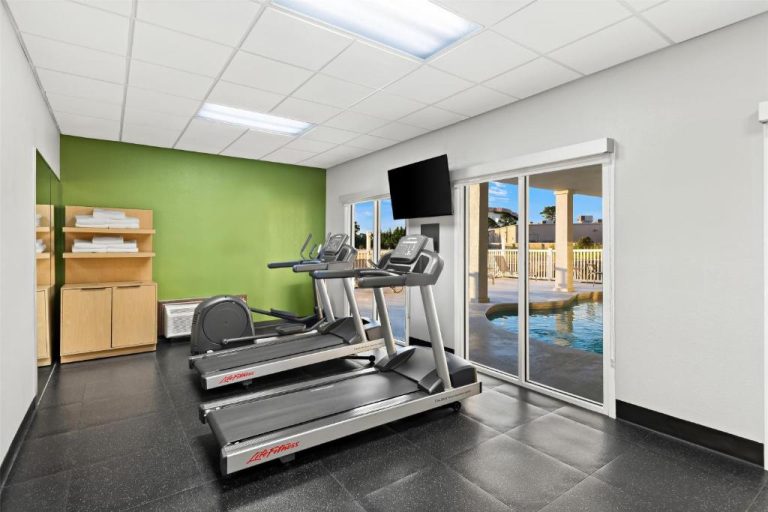 Gimnasio con cintas de correr Life Fitness y vistas a la piscina en Spark by Hilton Panama City Beach