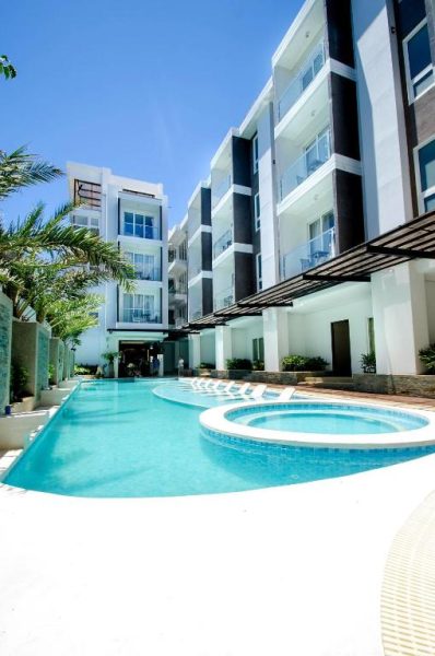 Piscina exterior y jacuzzi del Boracay Haven Suites con vistas al moderno edificio de apartamentos