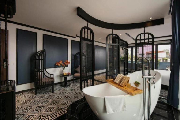 Lujosa bañera exenta con bandeja de madera en suite del Hanoi Le Chateau Hotel & Spa