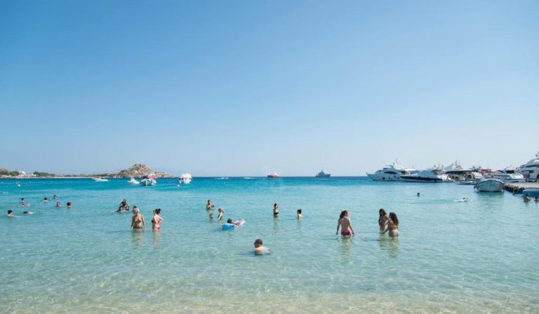 Bañistas disfrutando de las aguas cristalinas de la playa frente al Acrogiali Beachfront Hotel Mykonos