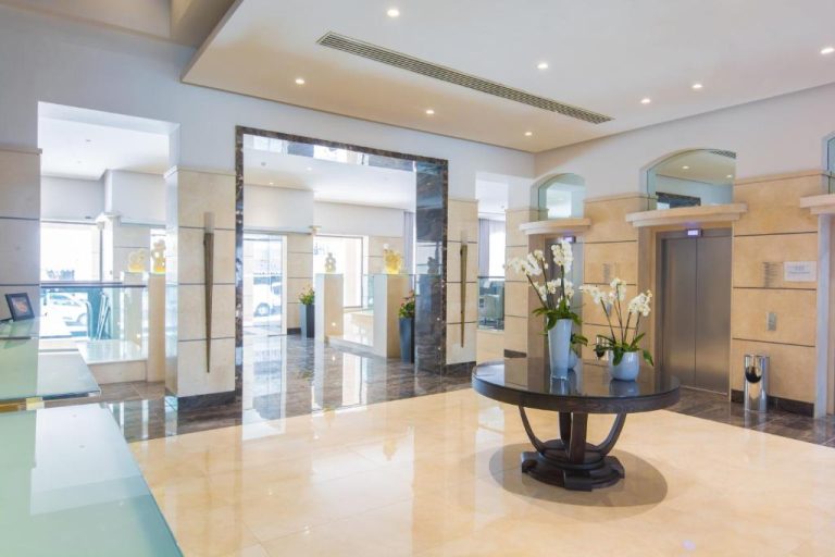 Elegante lobby con mesa de flores y ascensores del Maritim Antonine Hotel & Spa Malta