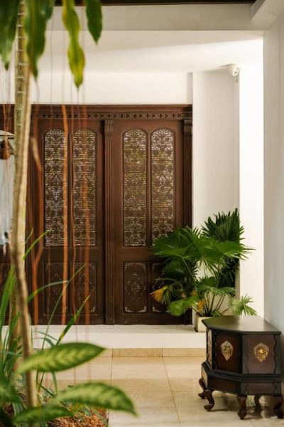 Puerta principal de madera tallada con detalles artesanales en la entrada del Jetwing Ratnam Residence