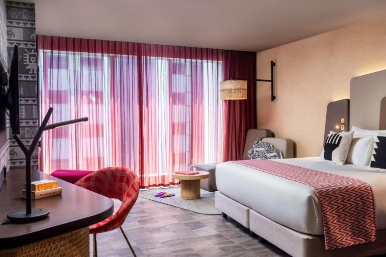 Habitación doble con decoración moderna y cortinas rojas en el hotel Nhow Lima