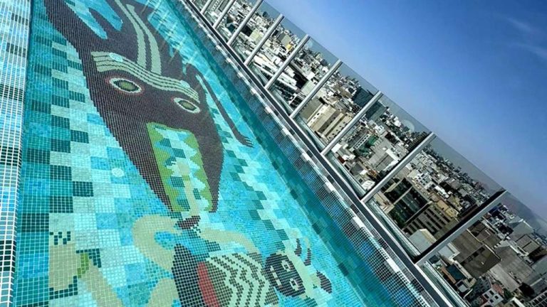 Piscina infinita con mosaico artístico en la azotea del Hotel Nhow Lima con vistas panorámicas a la ciudad