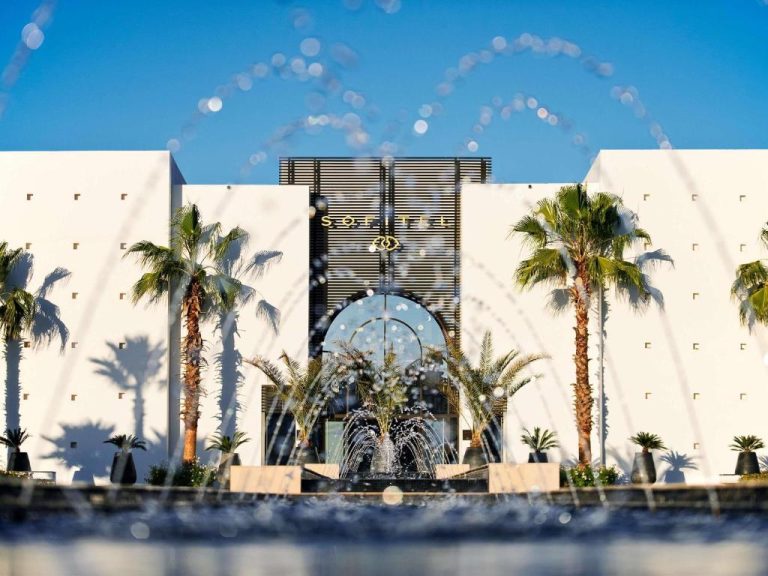 Fachada principal del Sofitel Agadir Thalassa Sea & Spa con fuente y palmeras bajo cielo azul