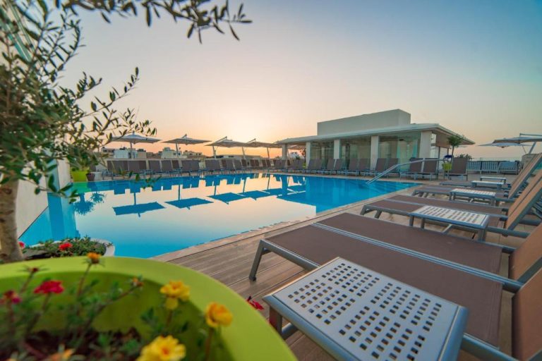 Piscina exterior con tumbonas y sombrillas del Maritim Antonine Hotel & Spa al atardecer