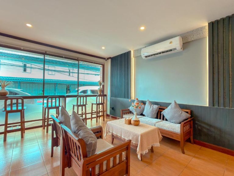 Sala de estar con sofás de madera y aire acondicionado en ClayHouse Samui Boutique Hotel