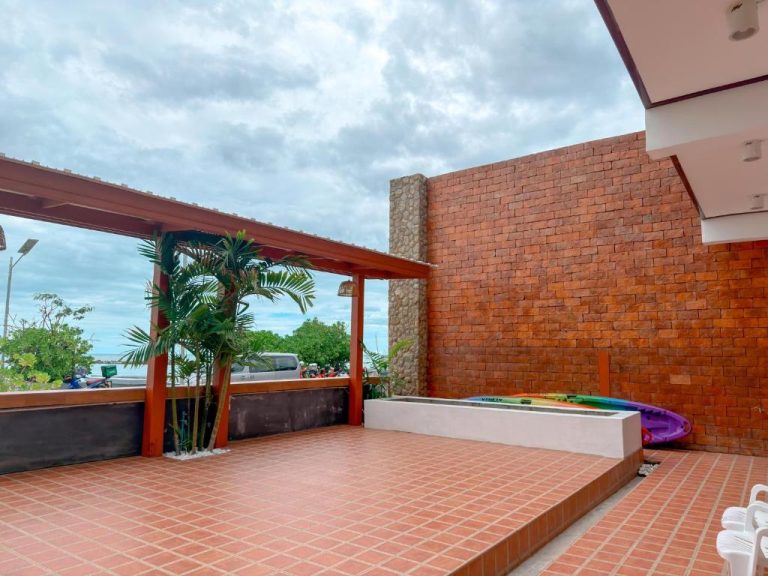 Terraza exterior con kayaks y pared de ladrillo del ClayHouse Samui Boutique Hotel en Tailandia
