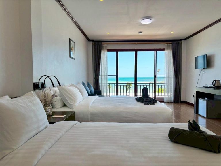 Habitación doble con camas blancas y vistas al mar turquesa en ClayHouse Samui Boutique Hotel