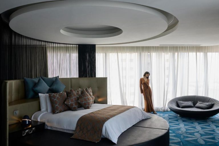 Suite de lujo con cama redonda y diseño circular en el techo del W Doha Hotel