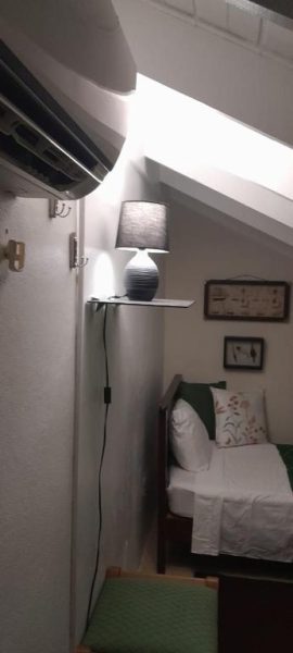Habitación abuhardillada con cama individual y lámpara decorativa en Deluxe SandCastles Condos