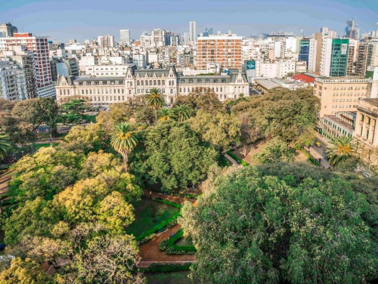 Vista aérea del Palladio Hotel Buenos Aires MGallery rodeado de parque arbolado y skyline de la ciudad