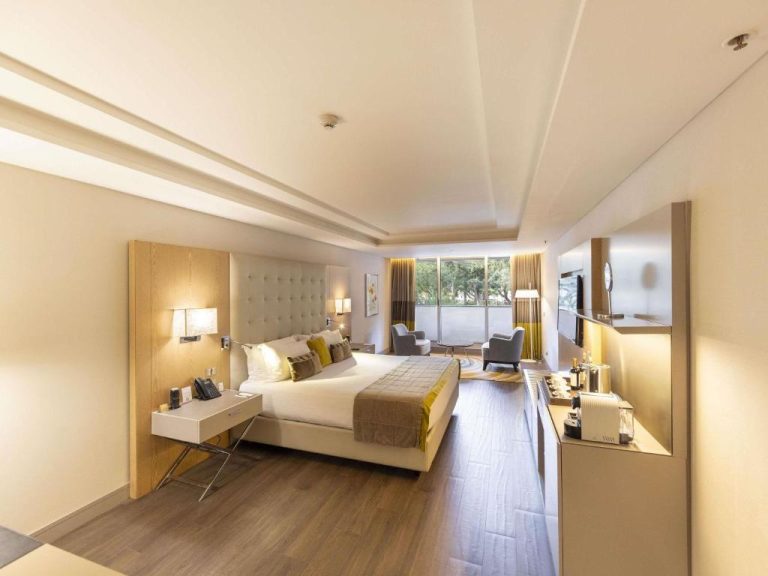 Habitación deluxe con cama king size y sala de estar en Palladio Hotel Buenos Aires MGallery