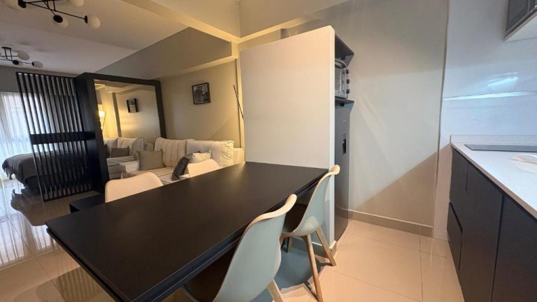 Comedor con mesa negra y sillas blancas integrado en cocina moderna del Centro Histórico Apart I
