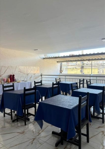 Restaurante con terraza del Hotel Sol Brasil con mesas de mantel azul y vistas al exterior