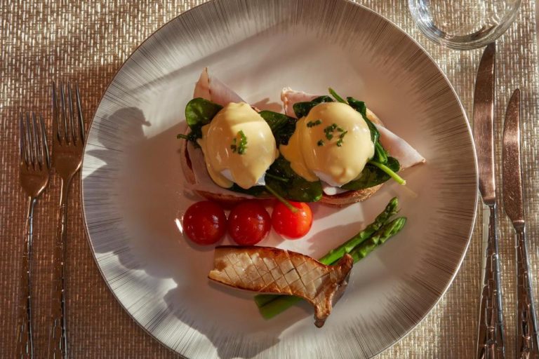 Elegante plato de eggs benedict con salsa holandesa y espárragos en el Mandarin Oriental Doha