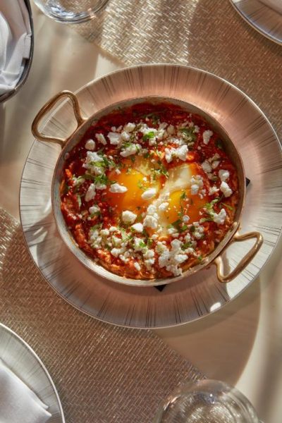 Shakshuka con huevos, salsa de tomate y queso feta servida en sartén de cobre en Mandarin Oriental Doha