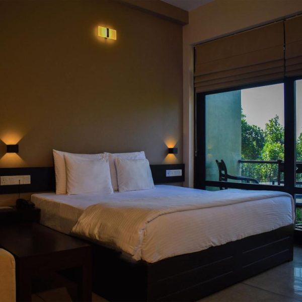 Habitación doble con cama king y balcón con vistas a la naturaleza en AHAS GAWWA Eco Lodge